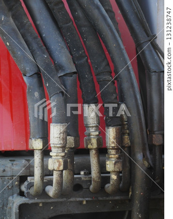 Bunch of black hoses are connected to a red pipe 131238747
