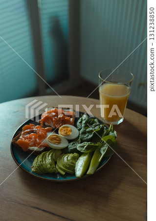 Healthy breakfast with salmon, egg, avocado, greens, and orange juice Healthy breakfast with salmon, egg, avocado, greens, and orange juice 131238850