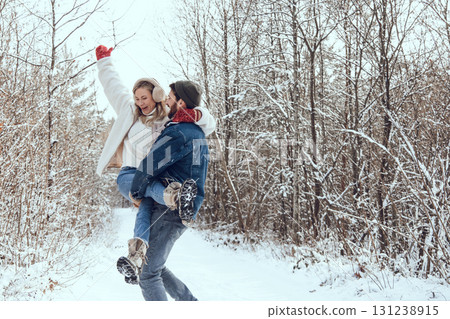 Cute couple enjoying winter time while walking in a forest Cute couple enjoying winter time while walking in a forest 131238915