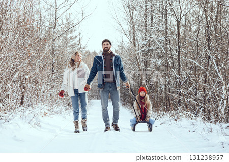 Young family looking happy and enjoyed while walking in a winter forest Young family looking happy and enjoyed while walking in a winter forest 131238957