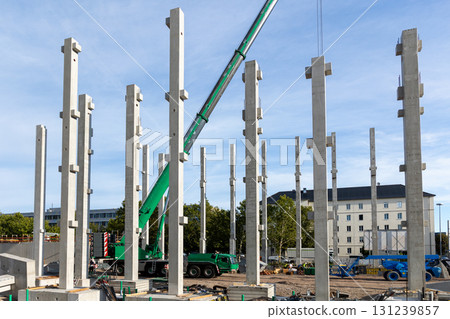 Extra heavy weight load mobile boom crane working modern city construction site with many concrete pillars blue sky background. Telescopic boom lifting equipment rental service. Industrial machinery Extra heavy weight load mobile boom crane working modern city construction site with many concrete pillars blue sky background. Telescopic boom lifting equipment rental service. Industrial machinery 131239857