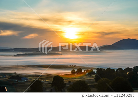 Orange sun rises over a misty countryside field in Zabljak, Montenegro, creating a warm and atmospheric autumn landscape. Perfect for travel, lifestyle, seasonal, and scenic background imagery. Orange sun rises over a misty countryside field in Zabljak, Montenegro, creating a warm and atmospheric autumn landscape. Perfect for travel, lifestyle, seasonal, and scenic background imagery. 131240295