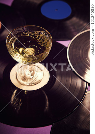 Whiskey cocktail with ice cube and garnish on glowing vinyl turntable 131240850