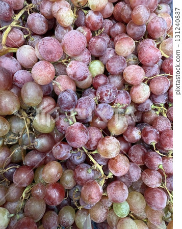 Dark reddish-blue grapes with translucent, tender, and juicy flesh. A container filled with grapes. Dark reddish-blue grapes with translucent, tender, and juicy flesh. A container filled with grapes. 131240887