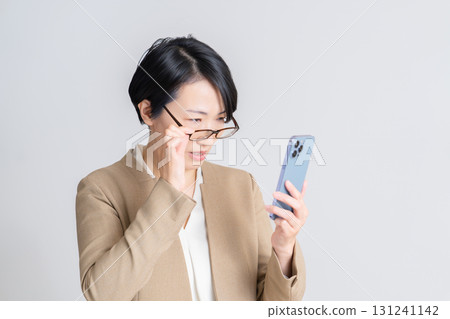 A woman watching a smartphone A woman watching a smartphone 131241142