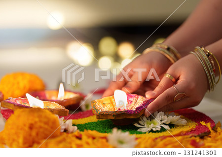 Diwali Candles and Rangoli with Floral Decorations 131241301