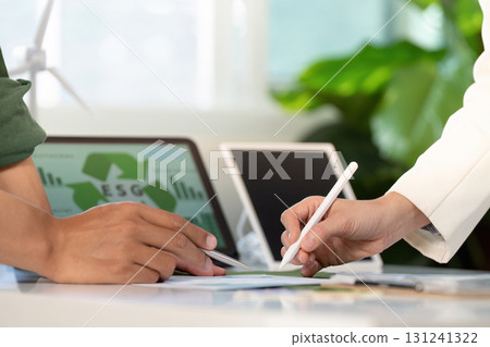 ESG collaboration. Professionals signing documents and discussing sustainable practices. 131241322