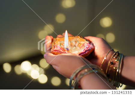 Diwali diya held with care, symbolizing light and hope Diwali diya held with care, symbolizing light and hope 131241333