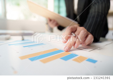Financial Analysis. Business professional pointing at growth charts. 131241391