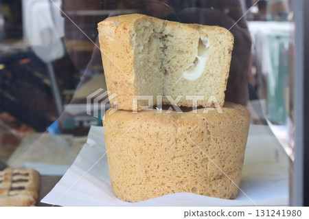 Delicious round bread loaf with cheese filling displayed in bakery window 131241980