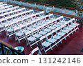 Rows of white chairs arranged on a boat deck, ready for an event. 131242146
