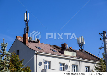 Cellular 5G antennas and satellite dishes on a building rooftop represent modern telecommunication infrastructure, powering urban network connectivity Cellular 5G antennas and satellite dishes on a building rooftop represent modern telecommunication infrastructure, powering urban network connectivity 131242626