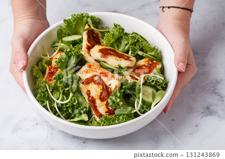 Cucumbers, sprouts and green leaves salad with fried halloumi. Cucumbers, sprouts and green leaves salad with fried halloumi. 131243869