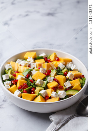Avocado, mango, pomegranate, and feta cheese salad in a white bowl. Avocado, mango, pomegranate, and feta cheese salad in a white bowl. 131243871
