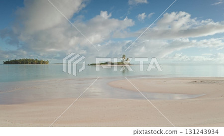 Drone fly over pink sand beach motu atoll, French Polynesia. Small tropical island with turquoise water lagoon and palm trees under cloudy blue sky. Remote wild nature paradise, exotic summer travel Drone fly over pink sand beach motu atoll, French Polynesia. Small tropical island with turquoise water lagoon and palm trees under cloudy blue sky. Remote wild nature paradise, exotic summer travel 131243934