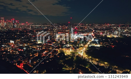England, London: aerial view of night London city, featuring illuminated buildings, streets, and traffic, creating a mesmerizing urban landscape under dark blue sky. Breathtaking drone flight panorama England, London: aerial view of night London city, featuring illuminated buildings, streets, and traffic, creating a mesmerizing urban landscape under dark blue sky. Breathtaking drone flight panorama 131243949
