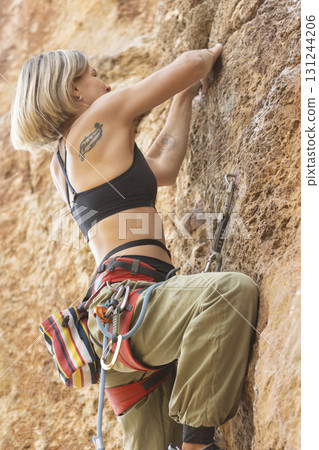 Woman rock climbing, engaging in extreme outdoors sport Woman rock climbing, engaging in extreme outdoors sport 131244206