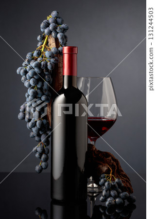 Red wine with a weathered snag and blue grapes. 131244503