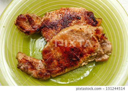 Top view of fried meat on a green plate. 131244514