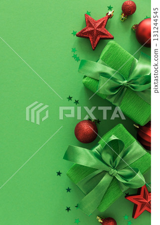 Green Gift Boxes with Red Ornaments and Star Confetti on Festive Background 131244545