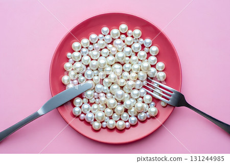 Scattered pearls on a pink ceramic plate with silver fork and knife, minimalist luxury concept on pink background Scattered pearls on a pink ceramic plate with silver fork and knife, minimalist luxury concept on pink background 131244985