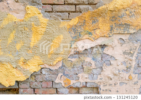 Old Brick Wall with Peeling Plaster and Paint Layers 131245120