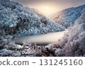 Scenic view of frozen ice lake and by snowy trees at sunset 131245160