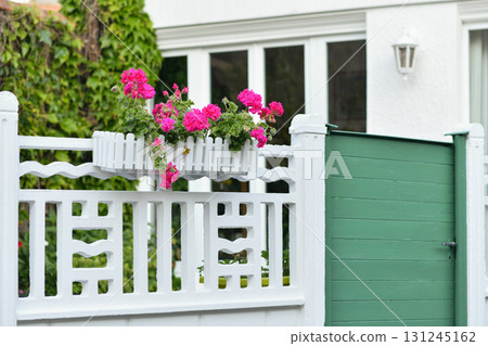 Pink geranium decorates the facade of a French white house Pink geranium decorates the facade of a French white house 131245162