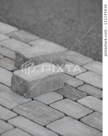 Two gray bricks are laying on a gray brick pavement Two gray bricks are laying on a gray brick pavement 131245616