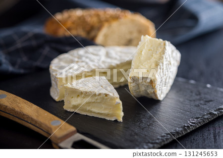 Camembert cheese on black table. French cheese with mold on the surface. Camembert cheese on black table. French cheese with mold on the surface. 131245653