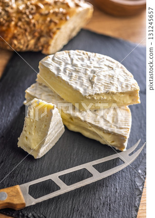 Camembert cheese on cutting board. French cheese with mold on the surface. Camembert cheese on cutting board. French cheese with mold on the surface. 131245657