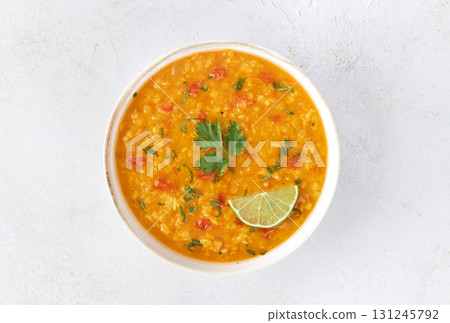 Red lentil soup with spices and fresh herbs on a gray background. Indian dal soup. Top view 131245792