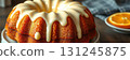 Delicious orange bundt cake with creamy glaze displayed on a white plate in a cozy kitchen setting 131245875