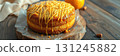 Delicious orange cake with caramel drizzle set on a rustic wooden table surrounded by fresh oranges and nuts 131245882