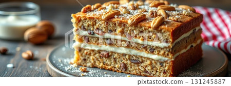 Delicious layered cake topped with nuts and icing served on a rustic wooden table 131245887