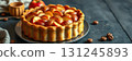 Freshly baked apple tart with golden crust and apple slices on display in a cozy kitchen setting 131245893