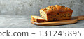 Freshly baked loaf of bread on a wooden cutting board surrounded by a rustic kitchen setting 131245895