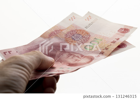 holding red Chinese yuan in a hand on a background, holding a large amount of money in yuan in the hands of a man 131246315