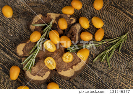 fresh sweet kumquat cut into halves close up, sliced orange kumquat fruits lie on the table during cooking 131246377