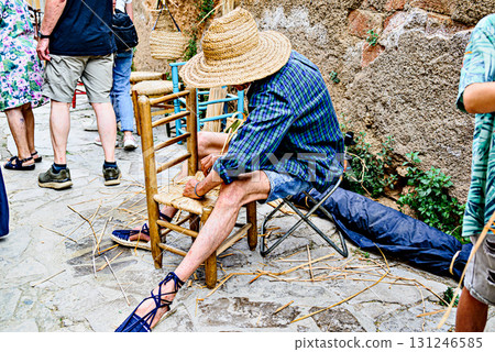 Representation of a wickerworker making a period chair in El Bruc, Barcelona 131246585