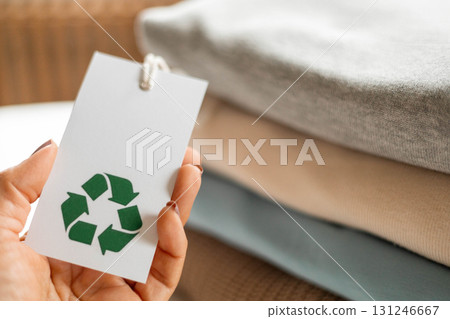 Recycled clothing tag in hand promoting eco-friendly and sustainable textile fashion Recycled clothing tag in hand promoting eco-friendly and sustainable textile fashion 131246667