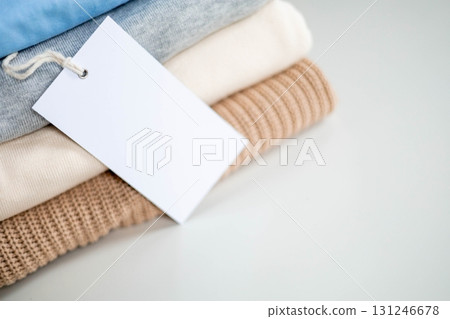 Stack of folded clothes with blank recycled label tag for eco-friendly and sustainable fashion 131246678