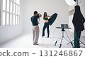 Photographer taking pictures of fashion model posing in studio 131246867