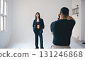 Photographer taking pictures of fashion model posing in studio 131246868