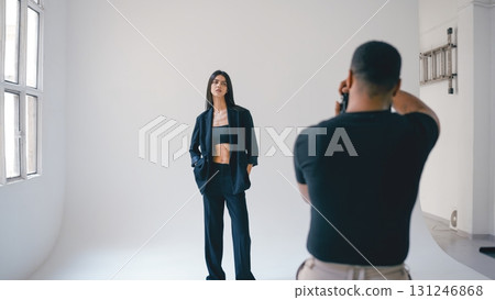 Photographer taking pictures of fashion model posing in studio Photographer taking pictures of fashion model posing in studio 131246868