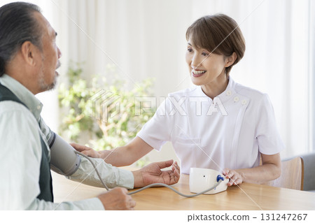Female medical staff measuring the blood pressure of a senior man 131247267
