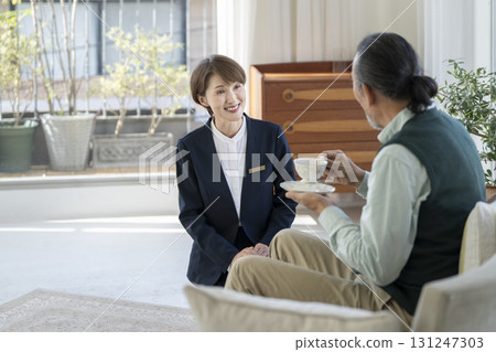 Female facility staff talking to senior man Female facility staff talking to senior man 131247303