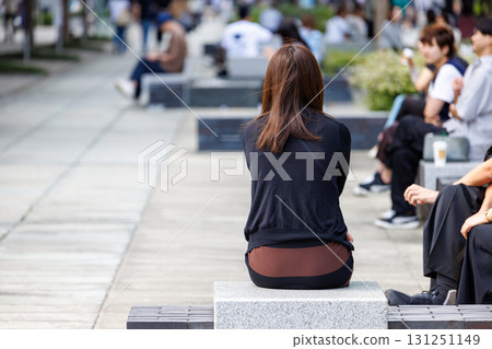 一位女士坐在辦公區公園長椅上的背影 一位女士坐在辦公區公園長椅上的背影 131251149