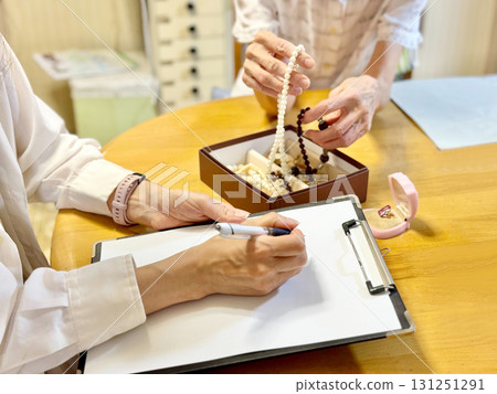 一位拿著配件盒的老年婦女和一位正在填寫表格的婦女 131251291