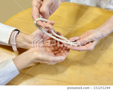 一位女士的手從一位老婦人手中接過珍珠項鍊 131251294
